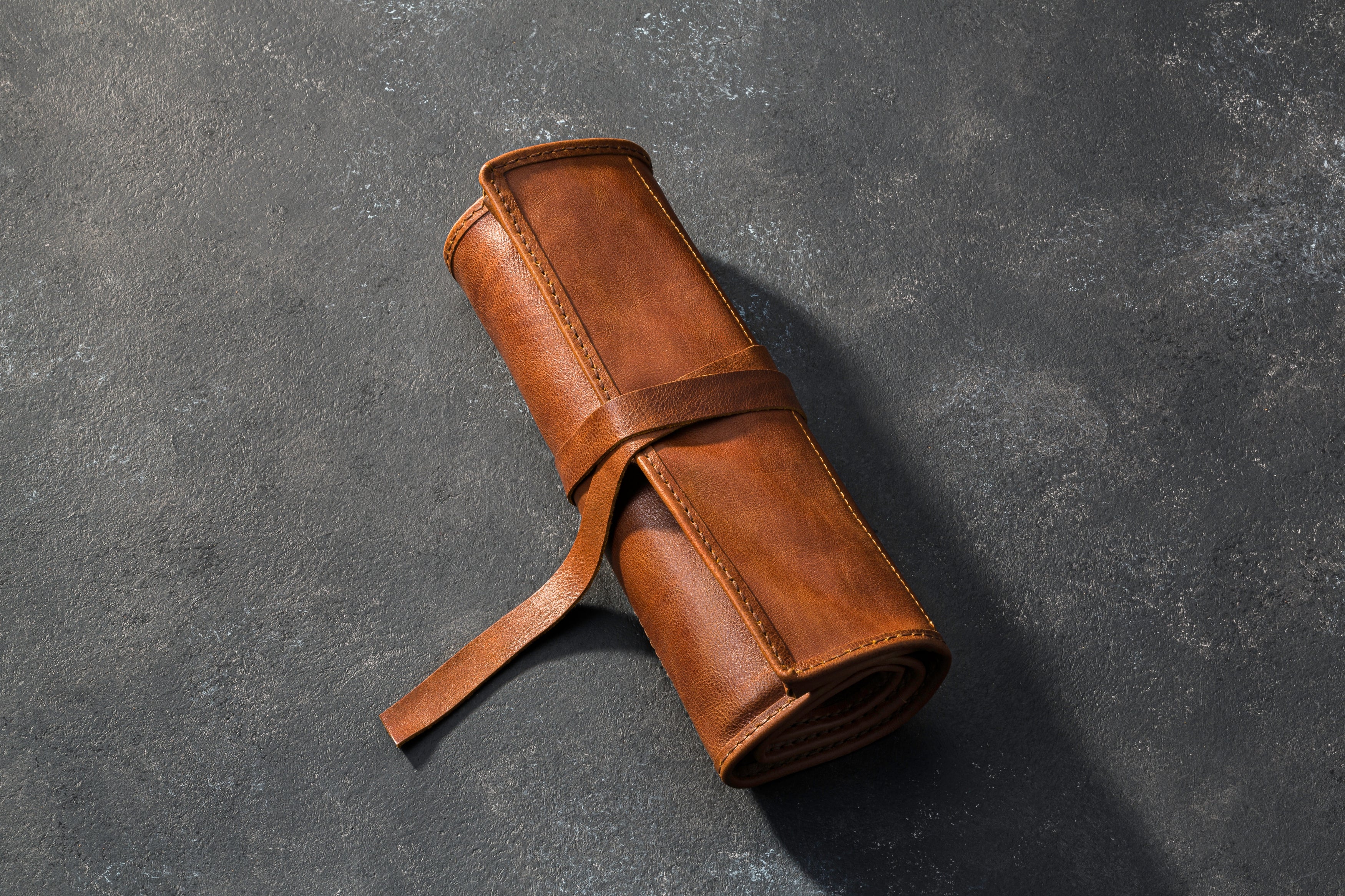 Brown leather roll on a dark gray background