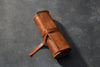 Brown leather roll on a dark gray background