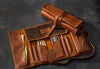 Brown leather roll-up case with various tools 