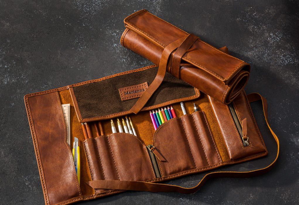 Brown leather roll-up case with various tools 
