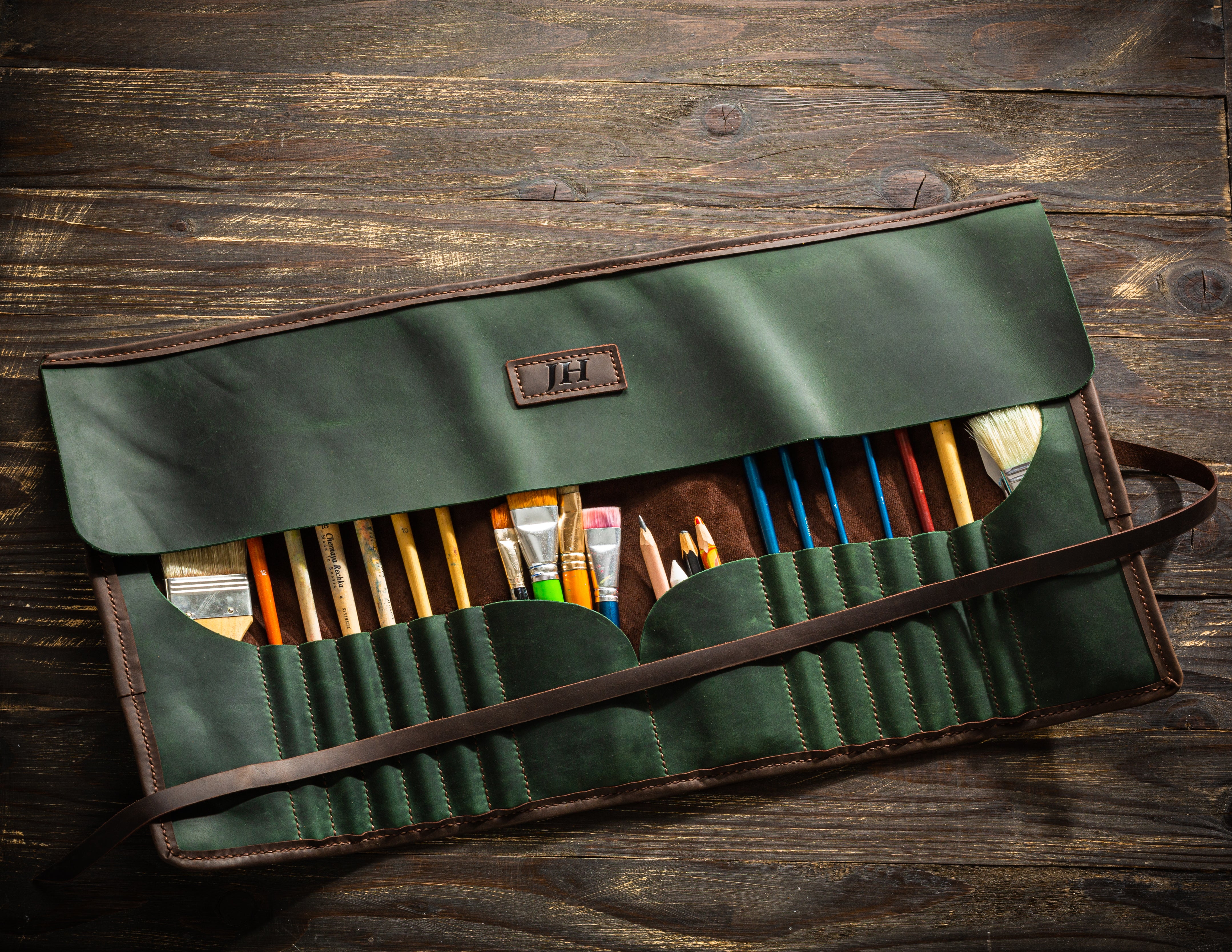 Handcrafted green leather artist roll with suede lining and painting supplies