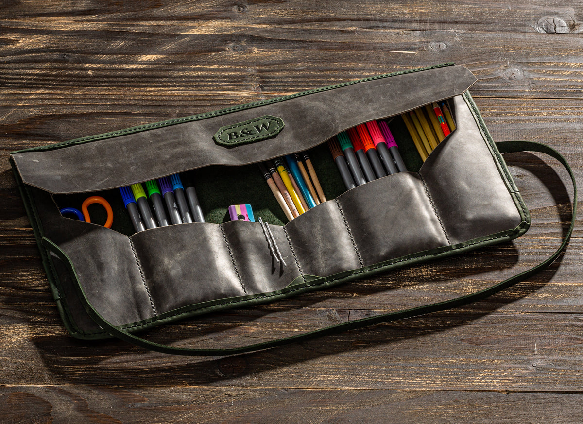 Personalized gray leather artist roll with olive green interior, multiple tool pockets and long wrap strap