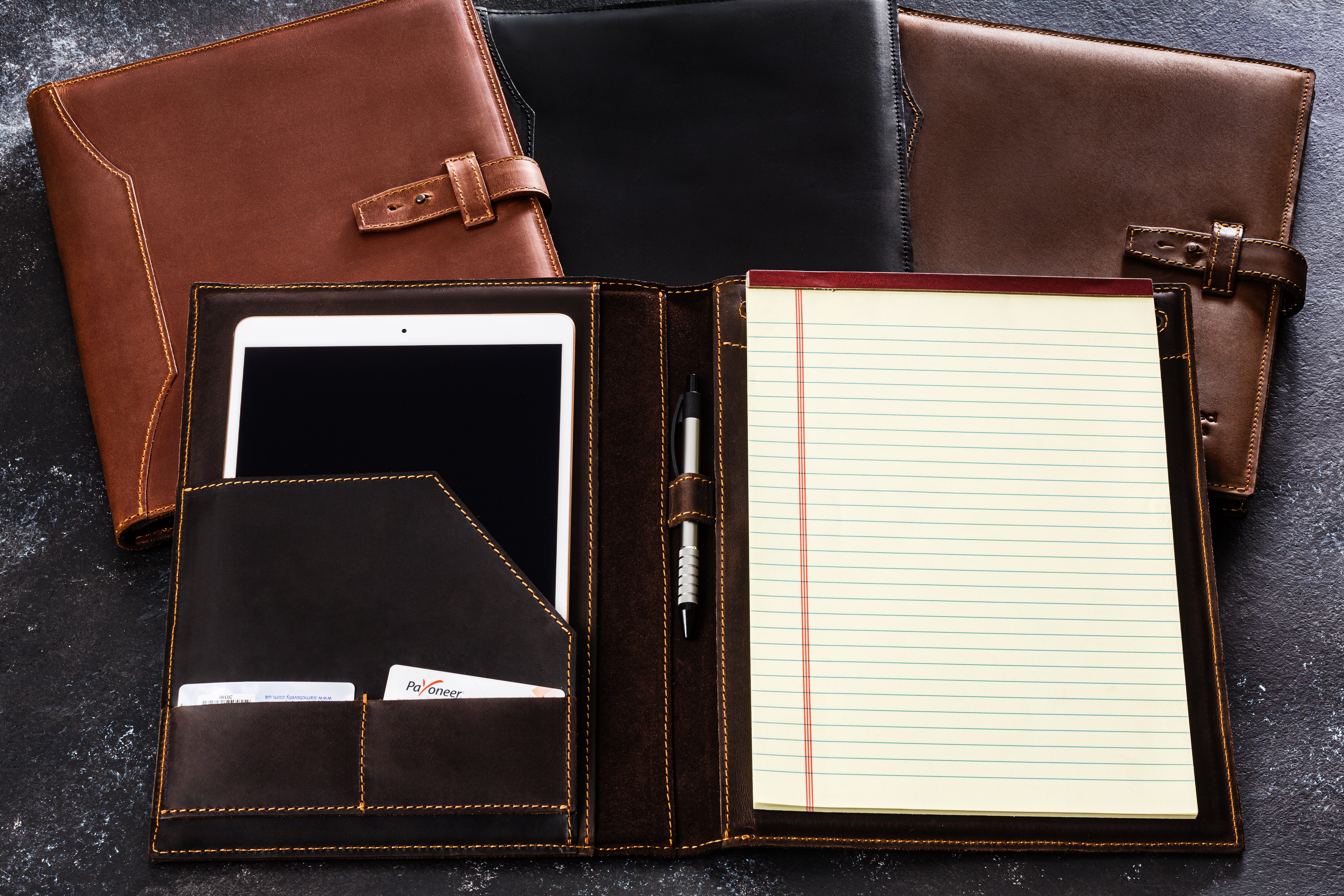 All color variations of Mureli handcrafted leather portfolios displayed on desk