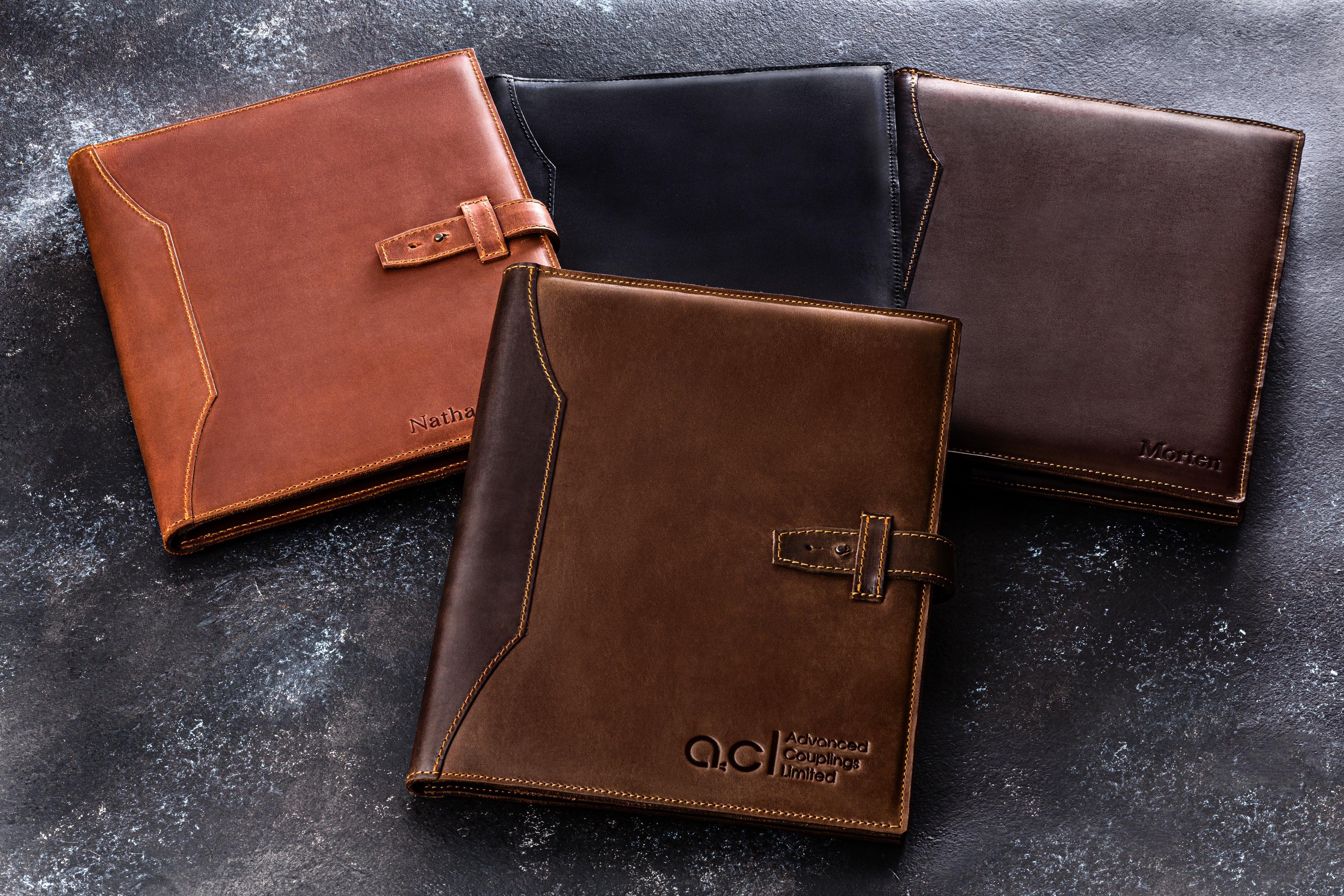 Collection of Mureli leather portfolios in black, brown, cognac, green, and honey yellow