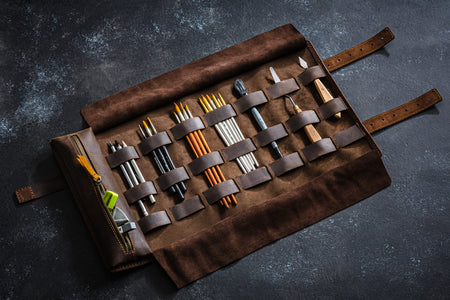 Leather artist tool roll unrolled with brushes and pencils