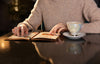 Close-up of hands flipping through a menu in a brown leather folder