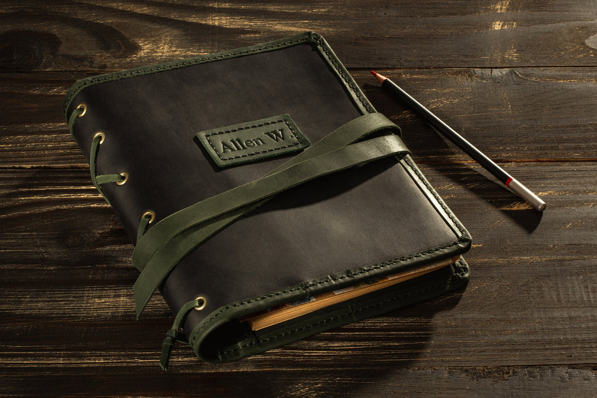 Personalized black leather sketchbook organizer with olive green wrap strap and custom name tag