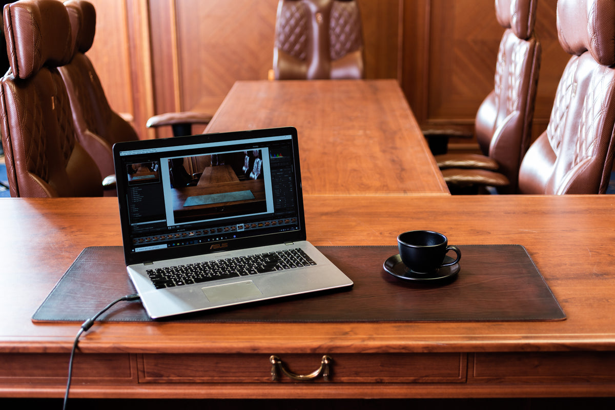 Thick Copper leather desk mat with hand-painted darkened edges on executive wooden desk with laptop and coffee cup