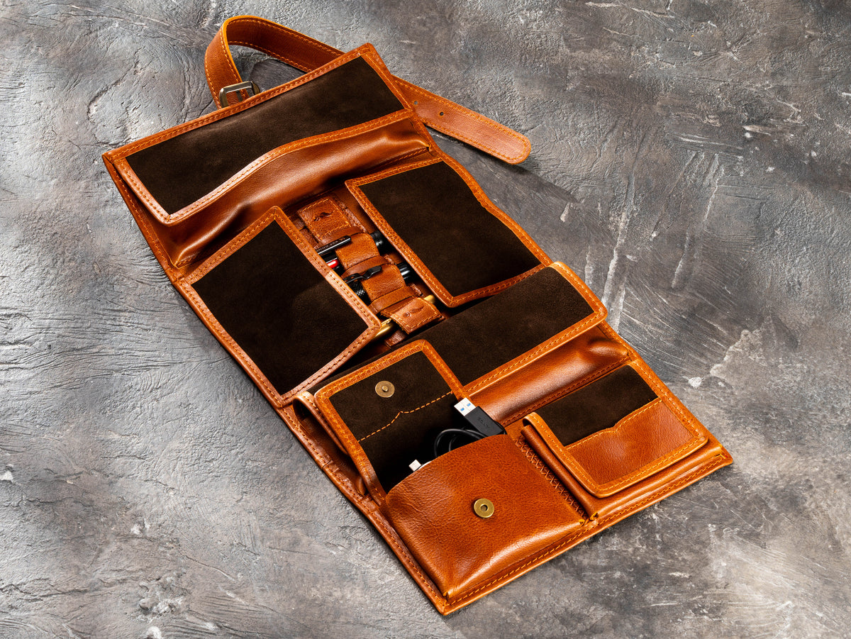 Camel hanging roll-up leather travel organizer opened with pockets for cables, chargers and everyday essentials
