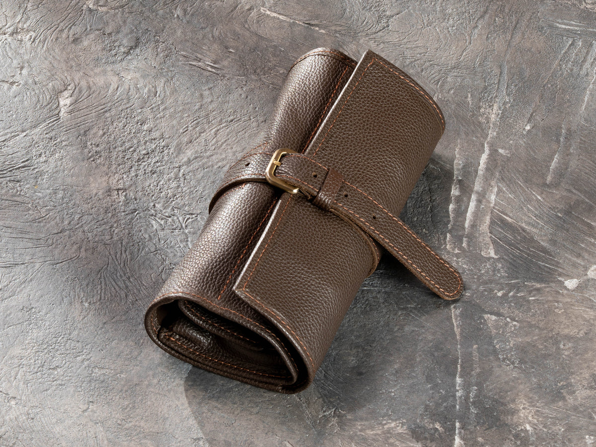 1. Closed Chocolate Brown leather roll-up travel organizer with adjustable buckle strap