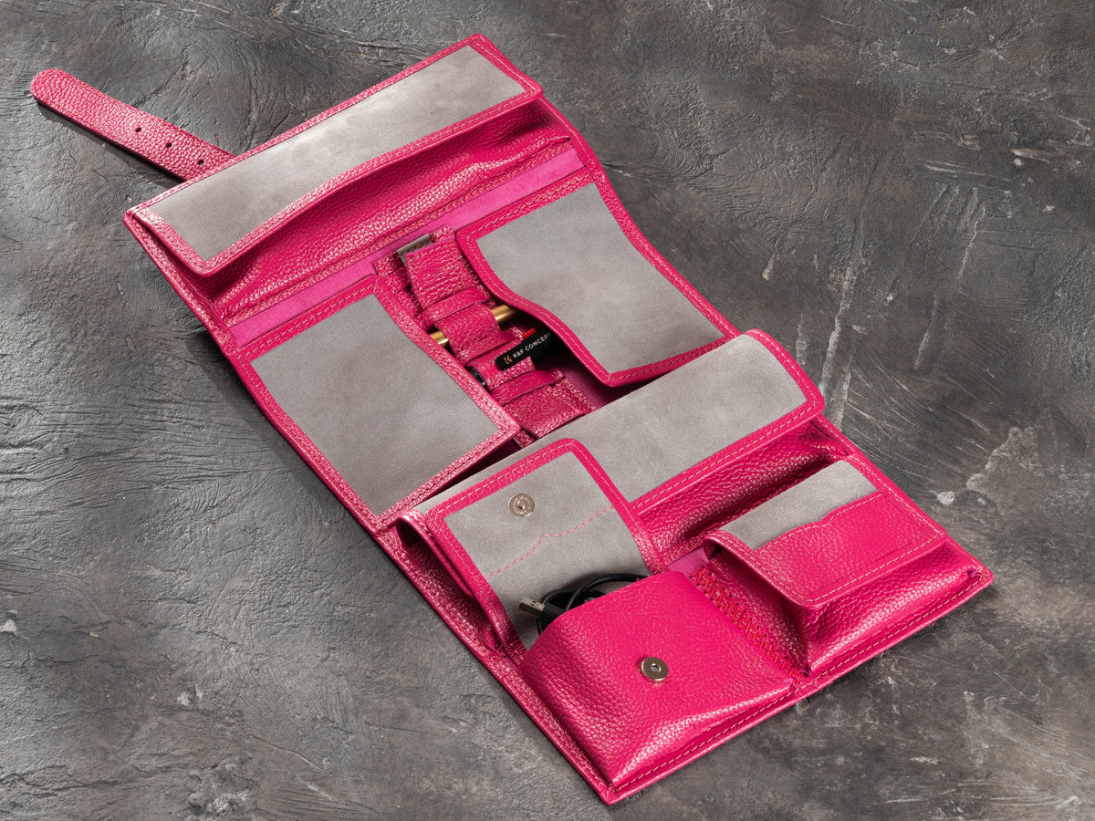 Open Raspberry Pink hanging leather travel organizer with magnetic pockets, soft suede lining and cable storage