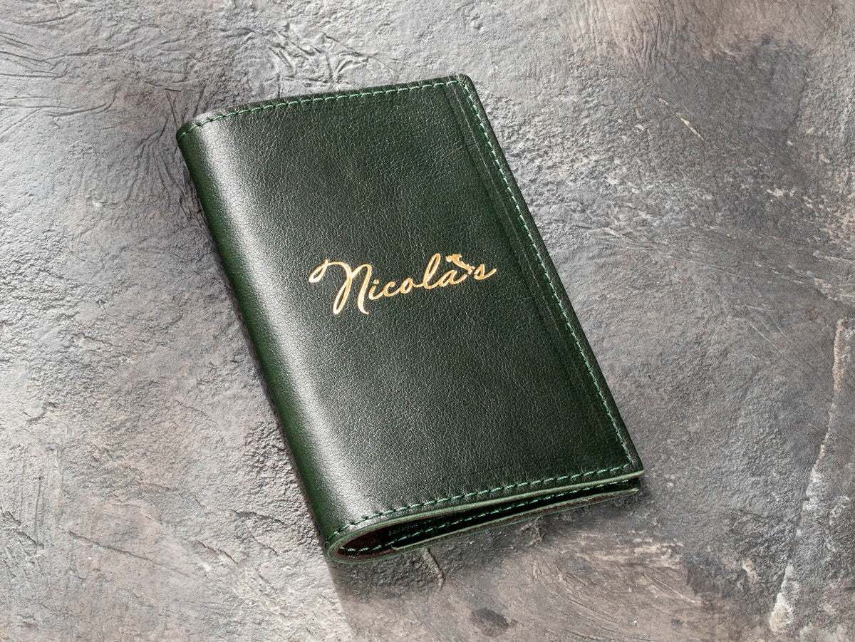 dark green leather restaurant check presenter with gold foil custom logo