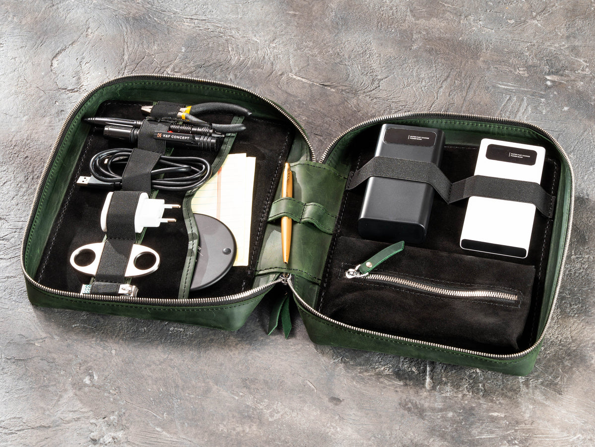 Open Forest Green leather travel organizer packed with chargers, cables, tools and outdoor trip essentials