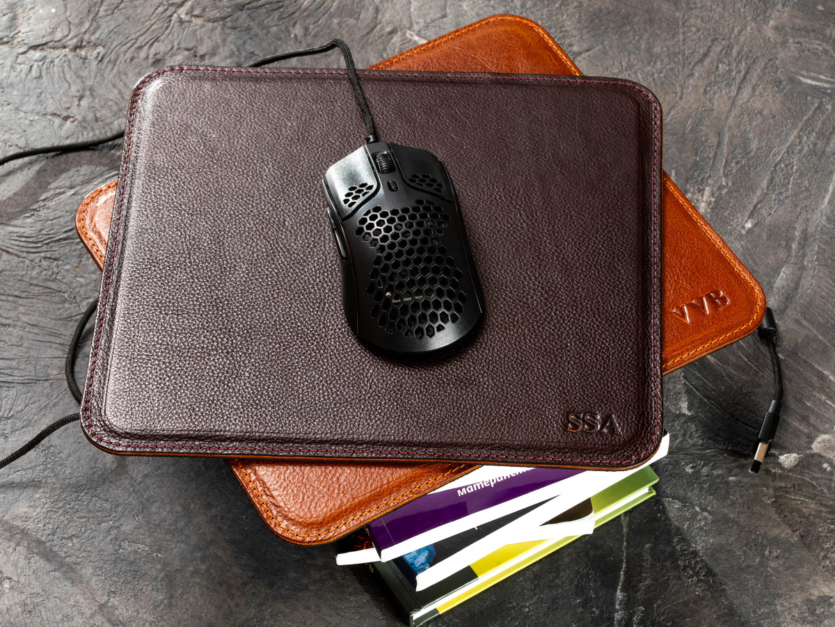 Dark Cognac leather mouse mat with wired mouse, Camel pad and books underneath
