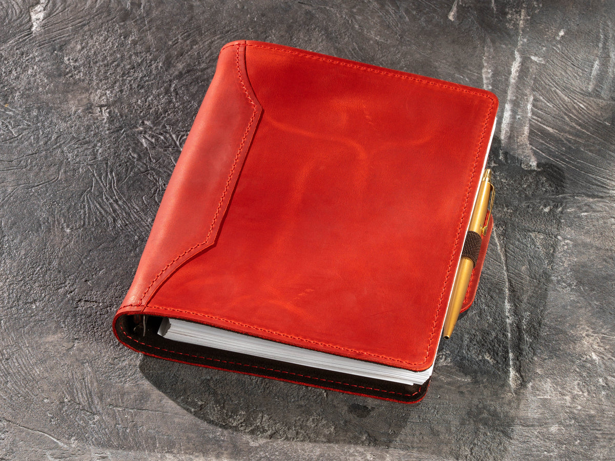 Red leather A5 and 8.5 x 5.5 notebook with gold pen secured in elastic pen loop