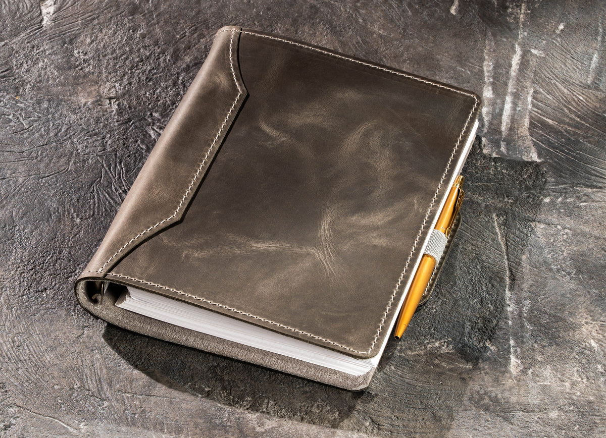Gray leather A5 and 8.5 x 5.5 notebook with gold pen secured in elastic pen loop