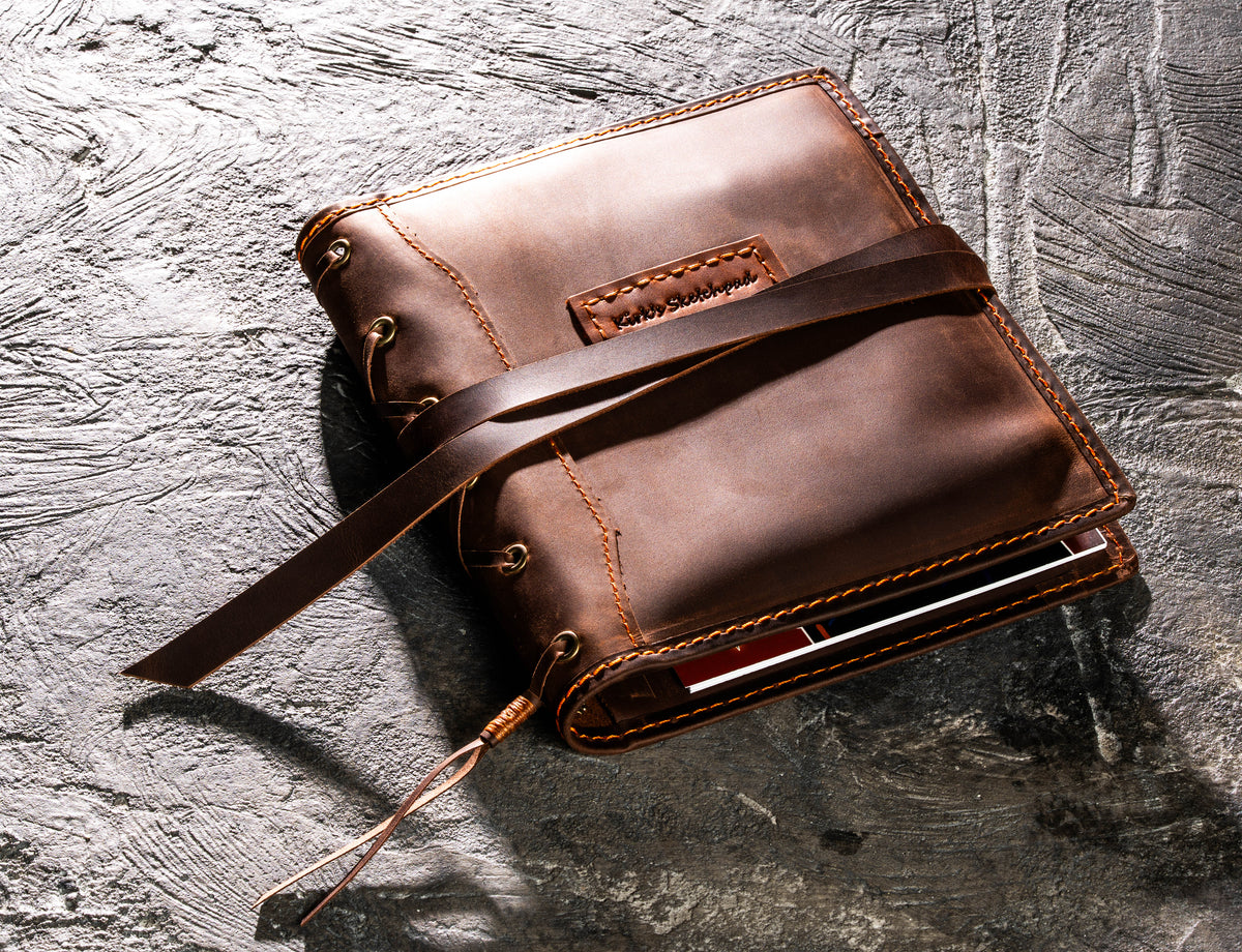 Brown leather A5 artist organizer with long wrap closure and personalized leather name tag