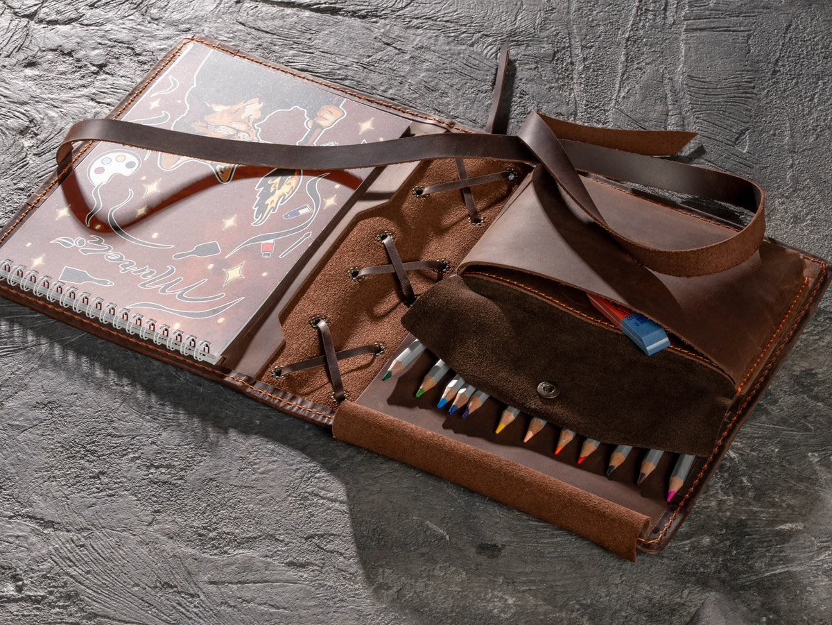 Open A5 leather artist organizer showing expanded pockets for pencils, eraser, lead tubes and compact drawing tools
