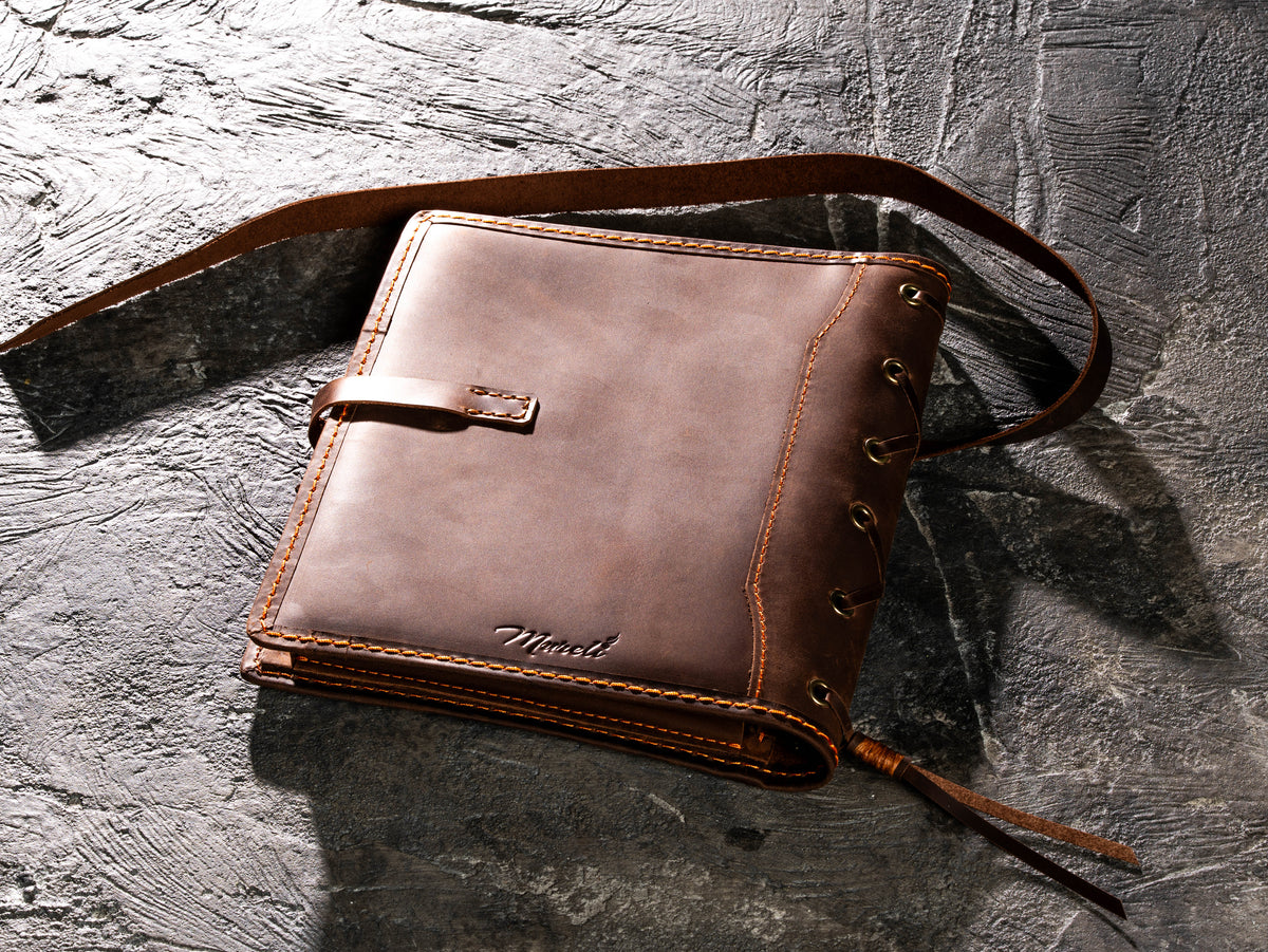 Back view of brown leather A5 sketchbook organizer with long wrap-around leather strap