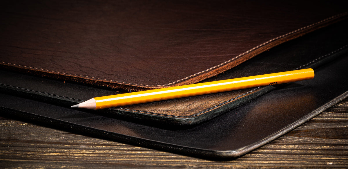 Extra thick 3–4 mm leather desk mats shown beside a pencil for thickness comparison, with hand-stitched leather edges