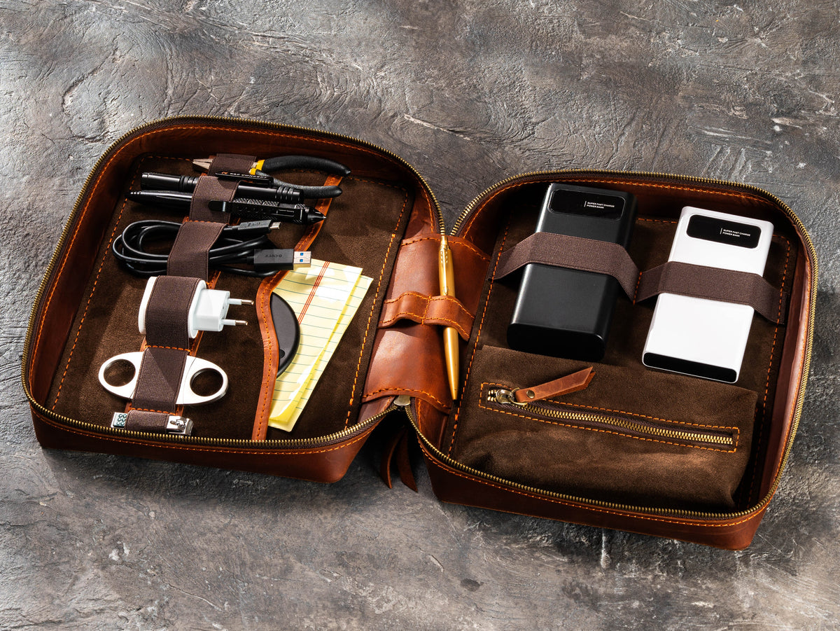 Copper Brown zippered leather travel organizer filled with chargers, cables, power banks and travel essentials